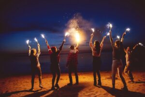 Motivated people on beach, holding up flares to tell you to relax and take baby steps